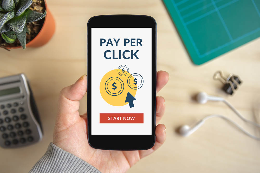 Hand holding smart phone with Pay Per Click (PPC)