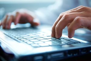 Hands typing on a keyboard