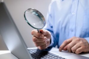Magnifying glass in front of a computer monitor
