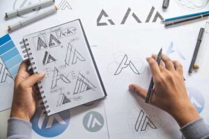 artist crafting logo designs on a notepad