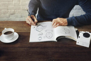 artist working on a desk with various design sketches