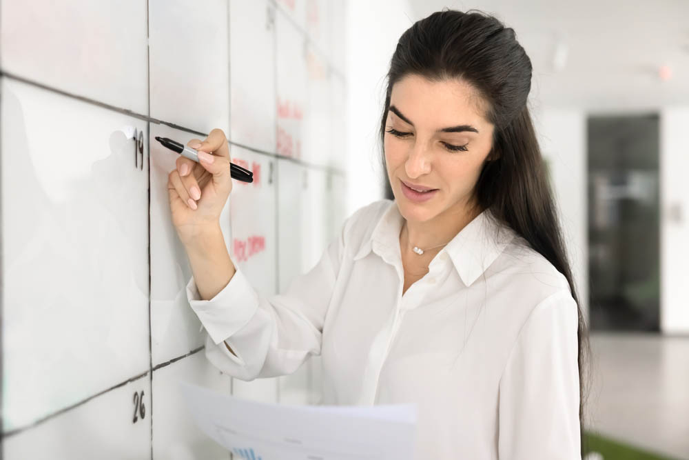 Person planning content on a calendar or whiteboard